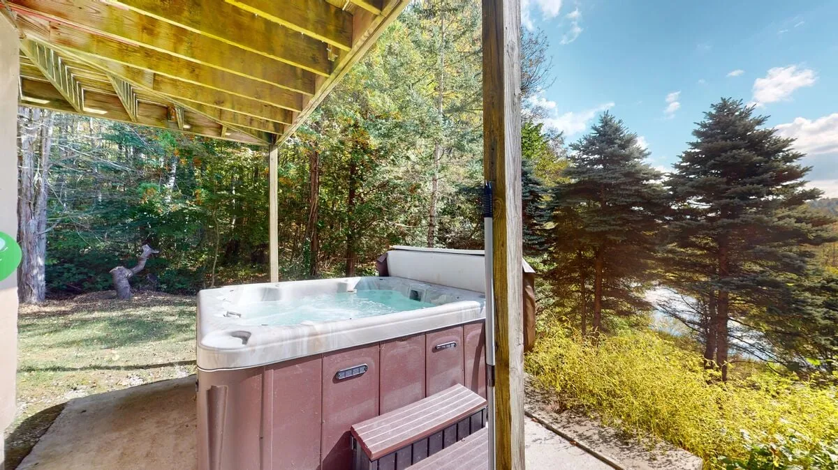 The hero image showcases the inviting outdoor hot tub surrounded by lush Vermont greenery, with towering trees framing the scene. The tranquil setting evokes a sense of privacy and natural beauty, promising relaxation under the open sky.